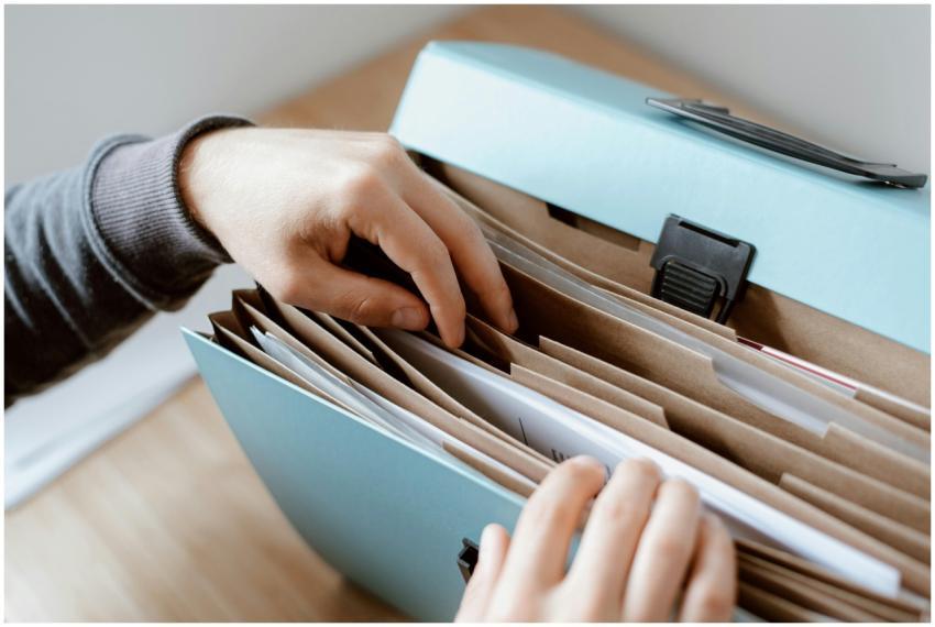 Close-up of hands organizing papers in a blue fold