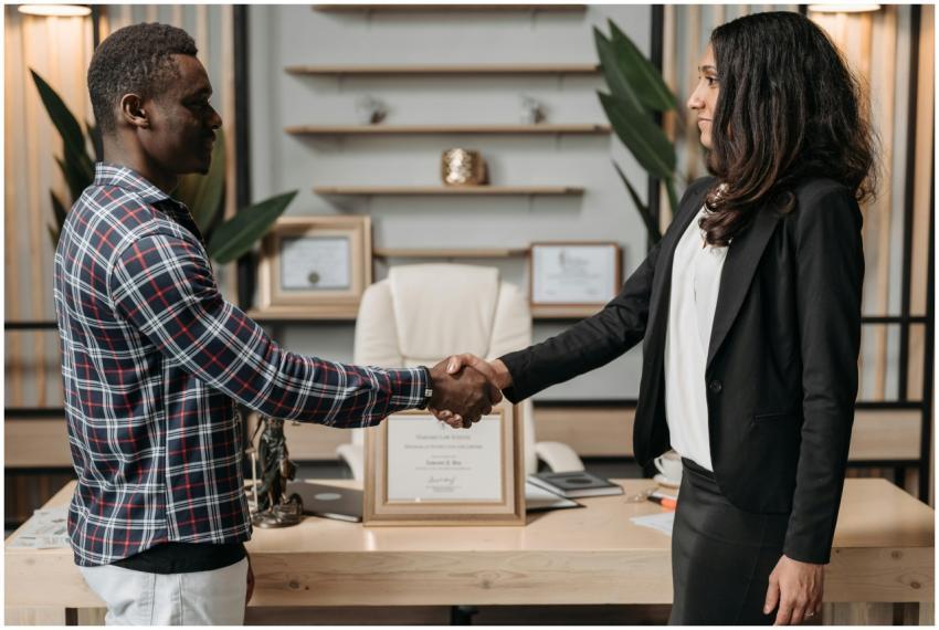 Two professionals shaking hands in an office, symb