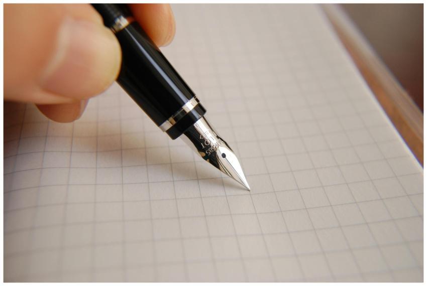 A detailed close-up of a fountain pen poised over