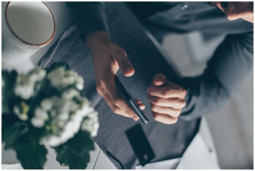 Top view of a man's hands holding a smartphone ind