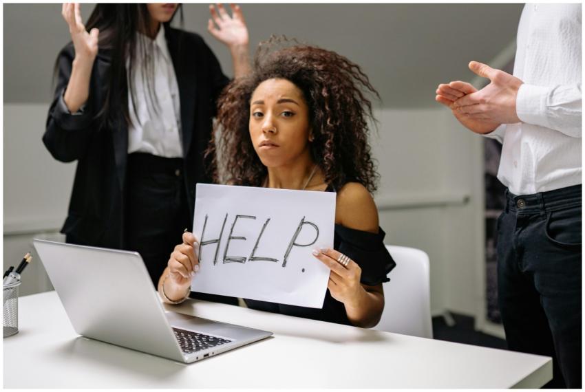 An unhappy businesswoman showing a sign reading 'H