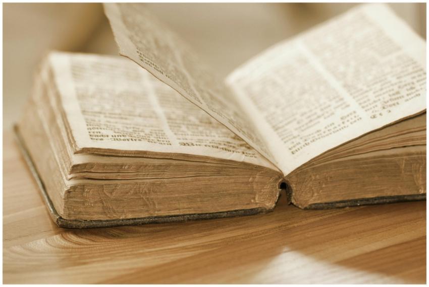 Vintage open book on a wooden table, highlighting