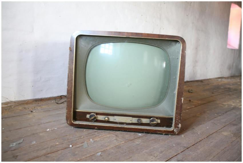 Vintage wooden television sitting on a dusty, rust