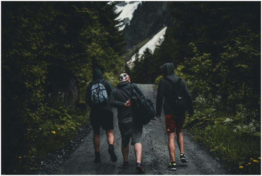Three friends walking on a mountain trail in Kitzb