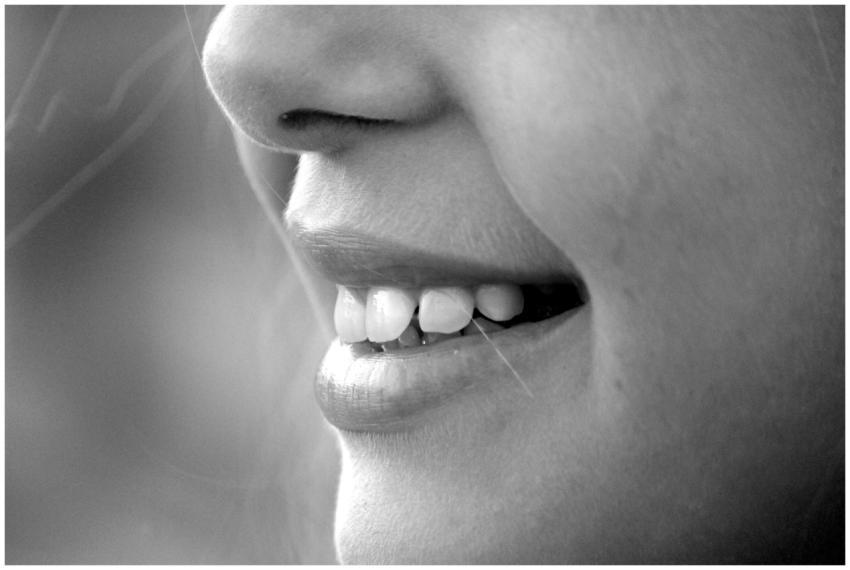 A monochrome close-up of a smiling face showcasing