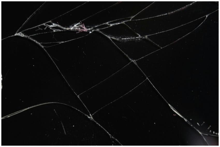Close-up of a cracked glass surface displaying int