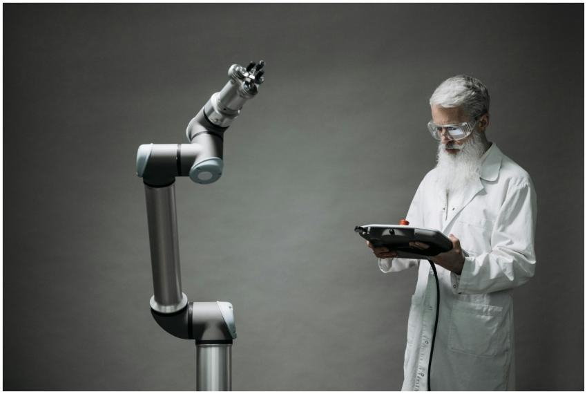 A scientist in a lab coat operates a high-tech rob