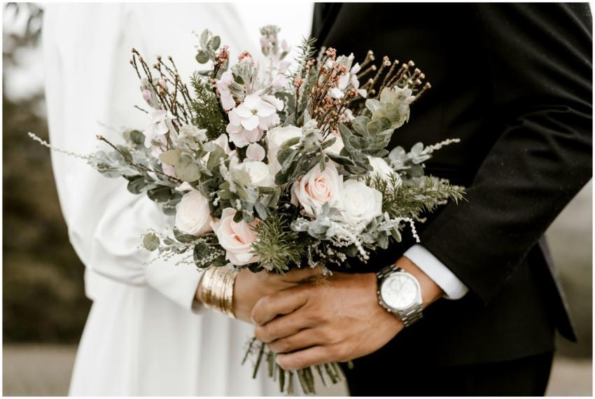 Close-up of a wedding bouquet held by bride and gr
