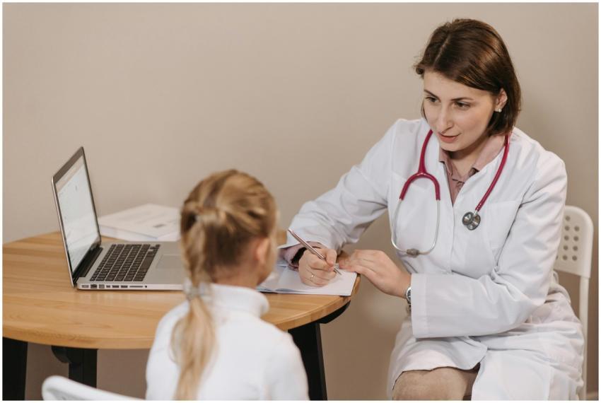 A female doctor listens attentively to a young gir