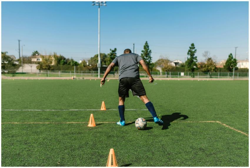 A soccer player practicing drills on a sunny day o