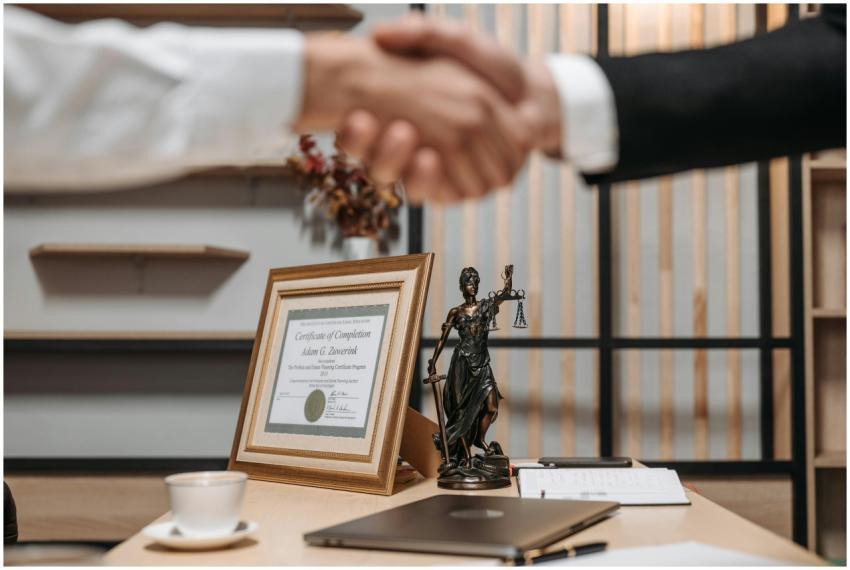 A professional handshake in an office with diploma
