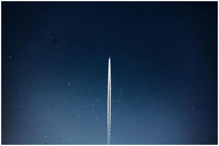 A rocket streaks through a starry night, leaving a