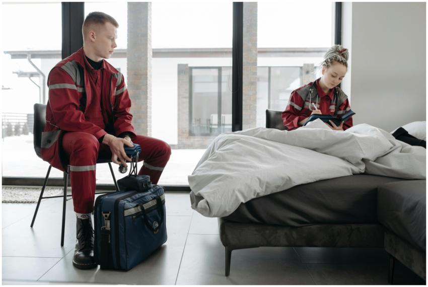 Two paramedics tend to a patient in a modern bedro