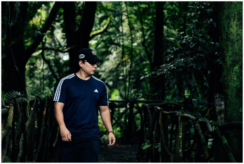 A man in athletic clothing walking through a lush,