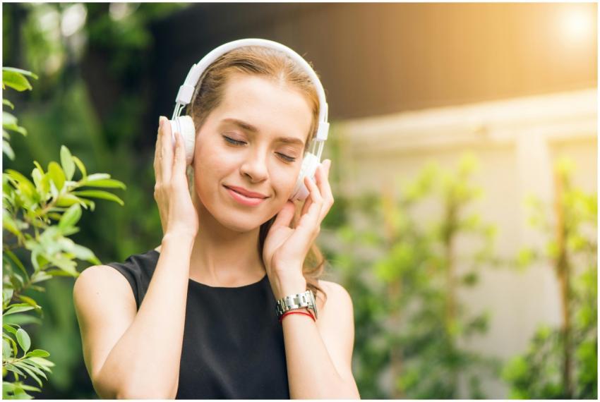 Smiling woman listening to music with headphones i