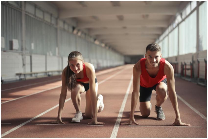Two athletes, a man and a woman, ready to sprint o