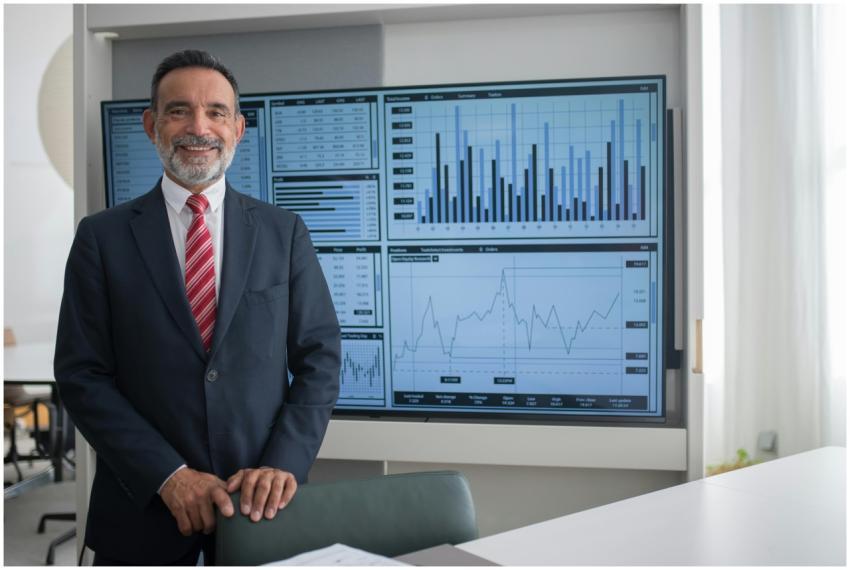 Smiling businessman in office analyzing financial