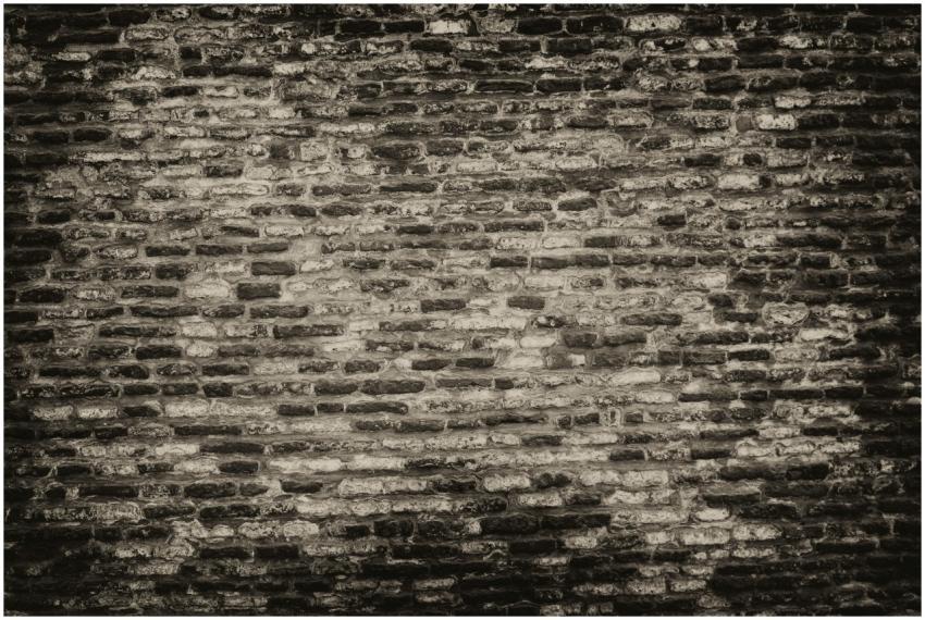 Grayscale textured brick wall background with roug