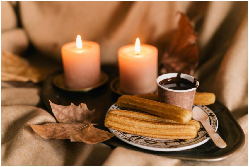 Warm churros and chocolate surrounded by lit candl