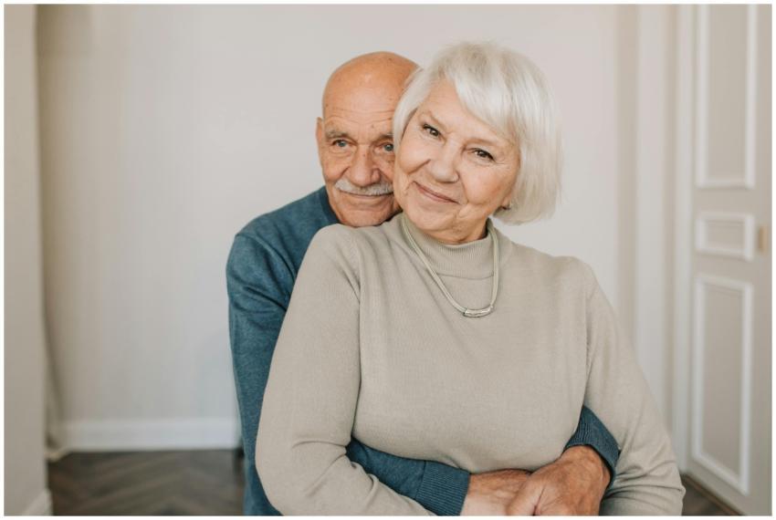 A loving elderly couple hugging indoors, showcasin