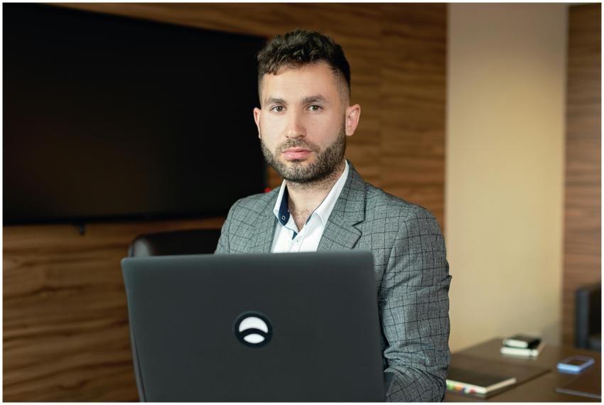 Businessman with facial hair working on a laptop i