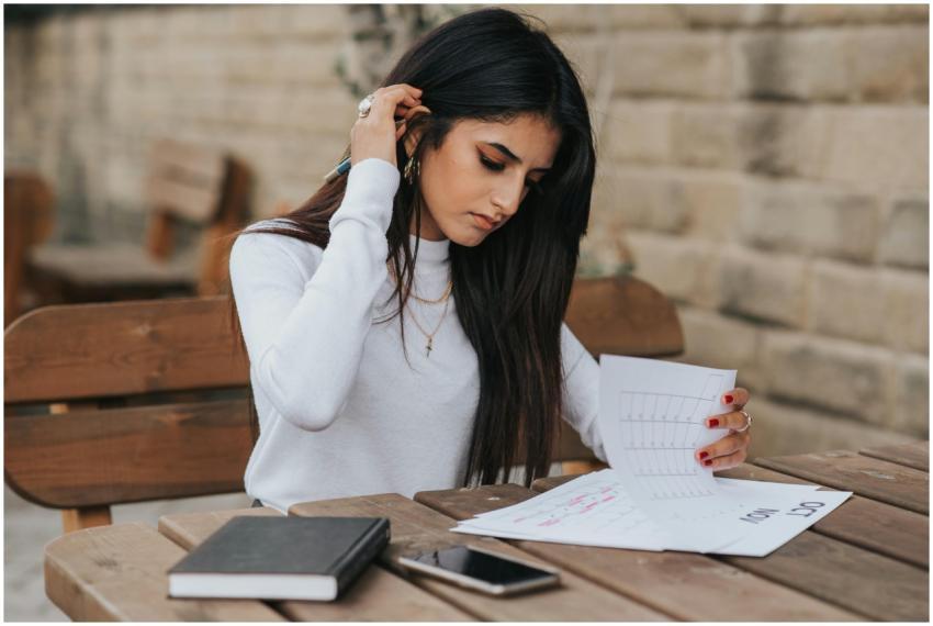 Focused young woman reviewing schedule outdoors wi