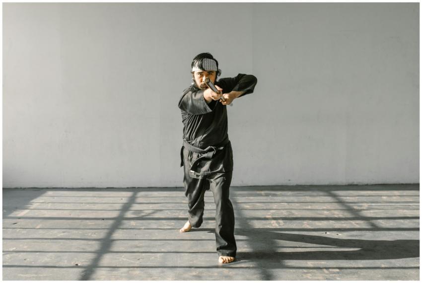 An adult Asian martial artist in a karate pose wit