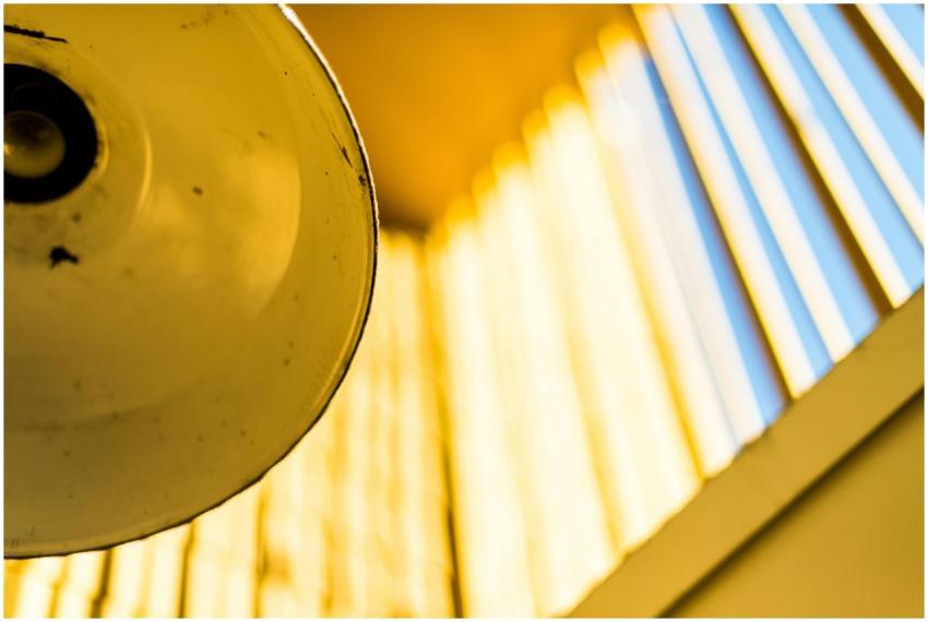 Artistic close-up of a yellow lamp and window shad