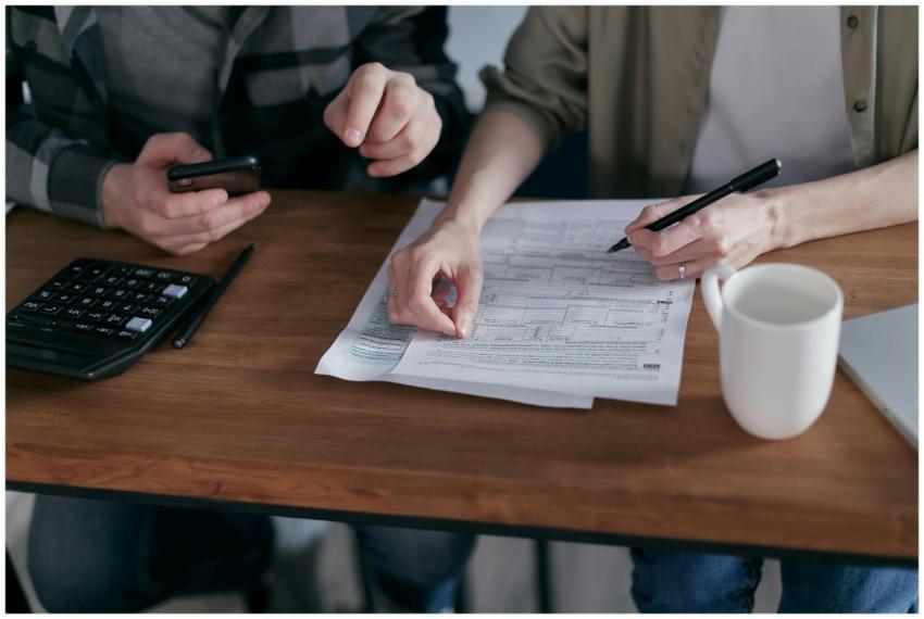 Couple managing finances at home with a calculator