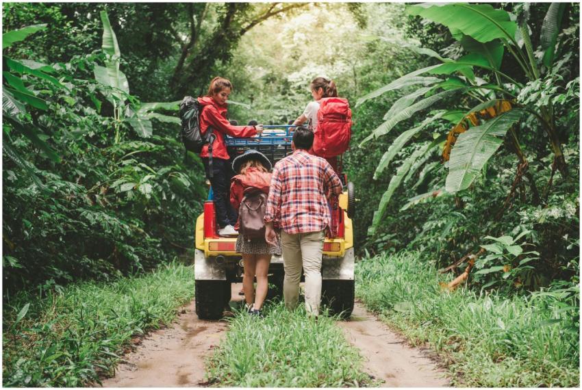 Friends hiking in a tropical forest, riding a jeep