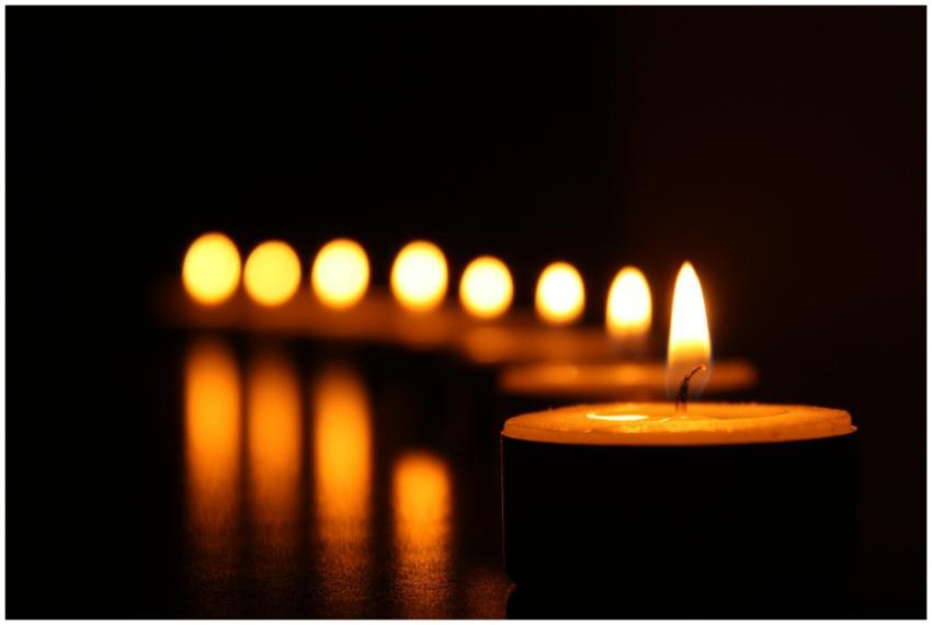 A close-up view of tealight candles reflecting a w