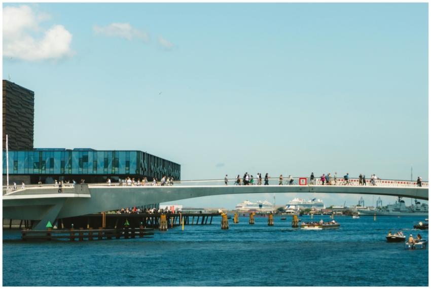 Pedestrian bridge in coastal city with people walk