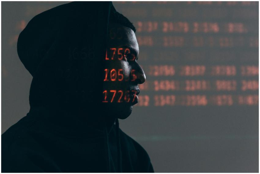 Side profile of a man in a hoodie, surrounded by r