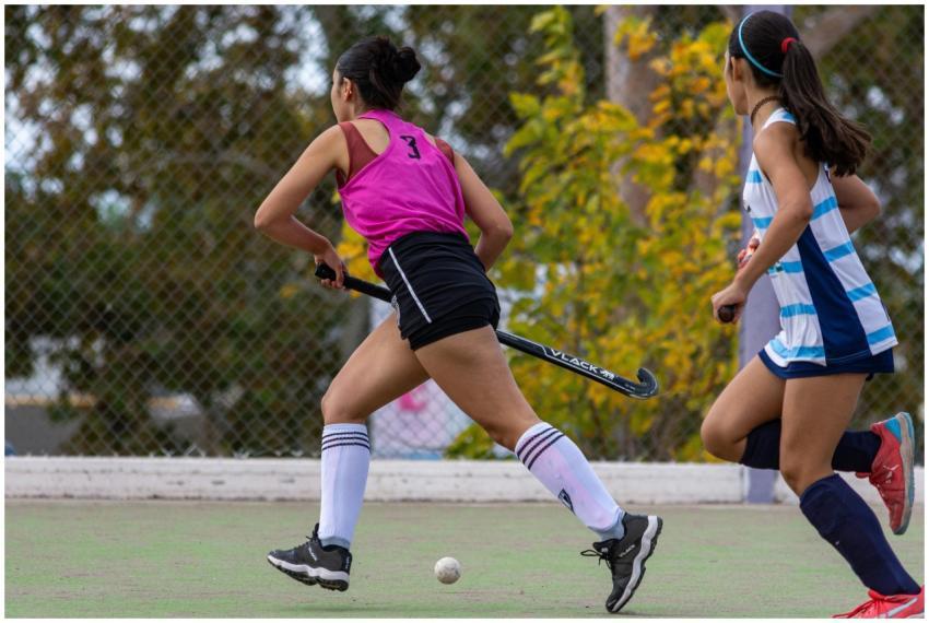 Teen girls engaged in an intense field hockey matc