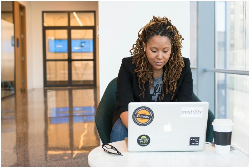 A woman focused on her laptop in a modern office e