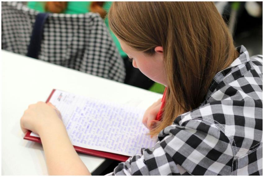 A young student writing in a notebook during a stu