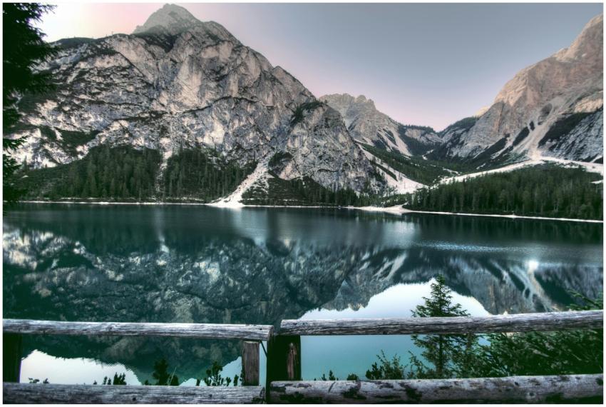 A serene mountain lake reflecting surrounding peak