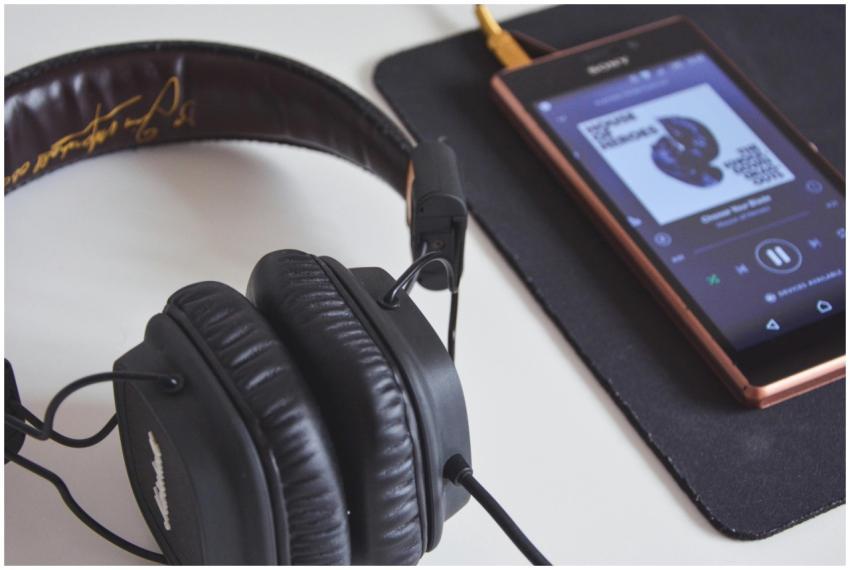 A close-up of headphones and a smartphone playing