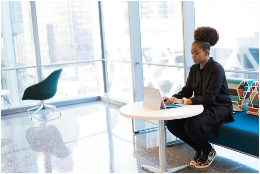 African American woman typing on a laptop in a bri