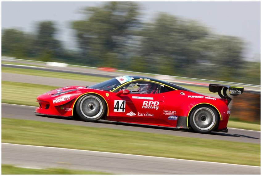 High-speed red race car in motion on track, captur