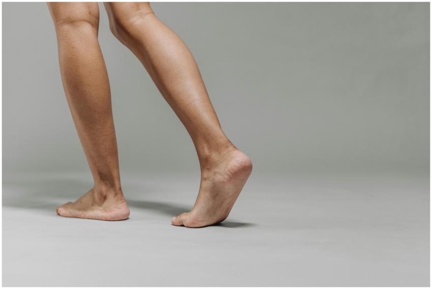 Close-up of adult bare feet on a neutral grey back