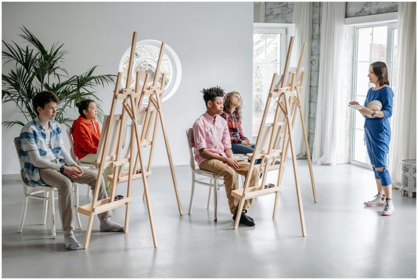 Students in an art class with easels, guided by a