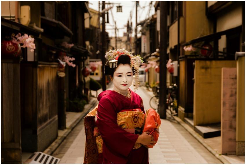 Geisha in vibrant kimono seen on a traditional str