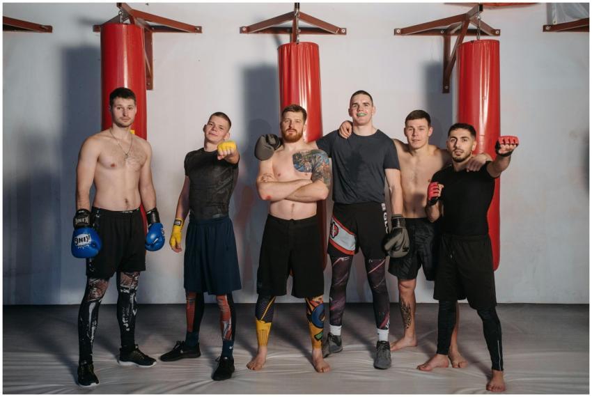 Six male boxers standing confidently in a gym with