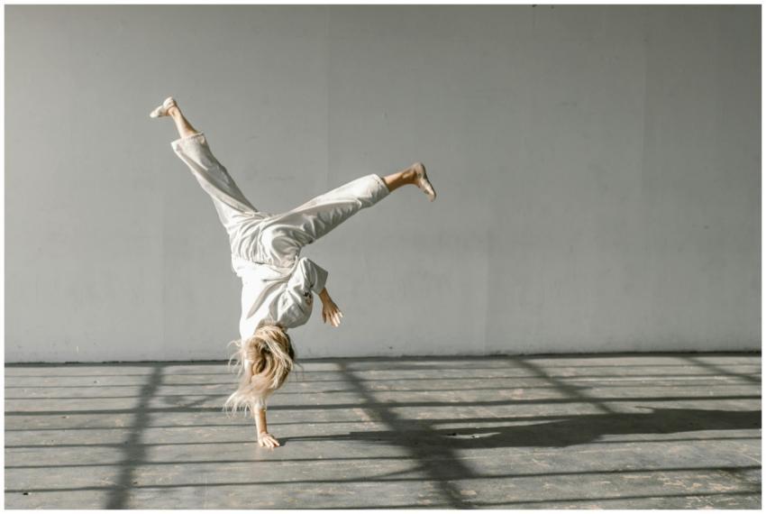 A martial artist executing a dynamic handstand ind