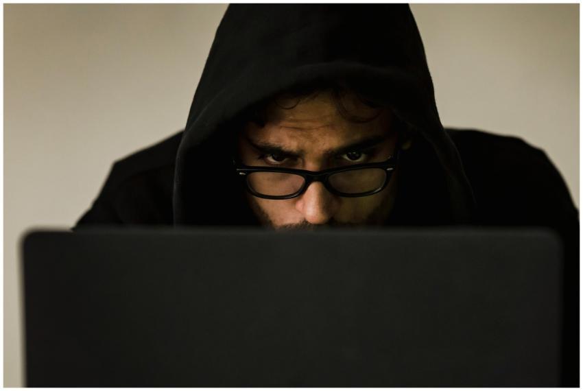 Serious young male programmer wearing black hoodie