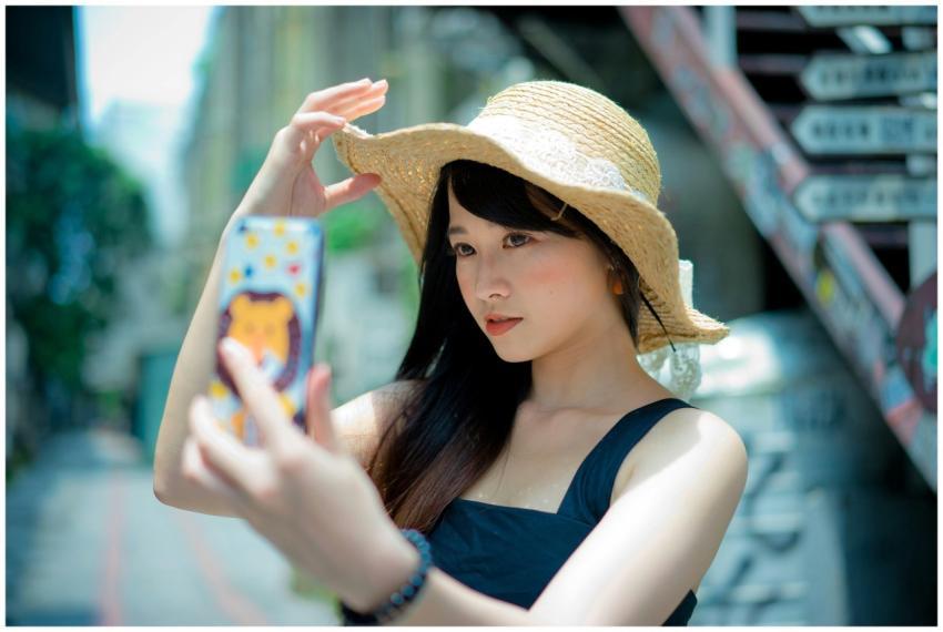 Beautiful Asian woman in a straw hat taking a self
