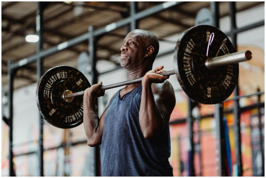 A senior man engaged in focused weightlifting at a