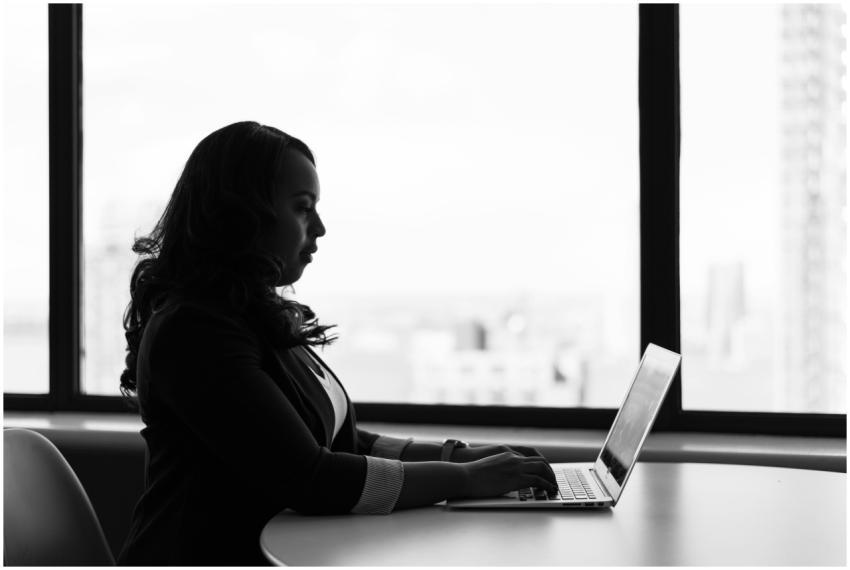 Black and white image of a woman working on her la