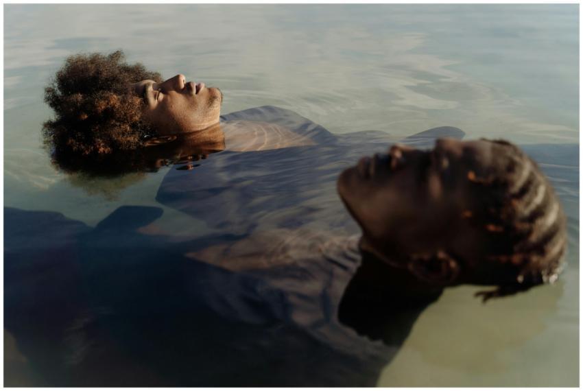 Tranquil scene of two adults floating on water, em